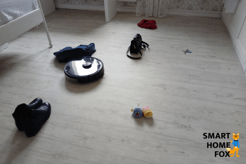 робот пылесос Roborock S6 MaxV стоит на полу перед подготовленными препятствиями.